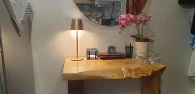 a wooden table with a lamp and flowers on it at Bel appartement moderne au cœur de guelize in Marrakech