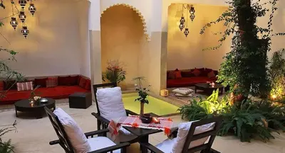 a living room with chairs and a table and a couch at Riad Davia in Marrakech