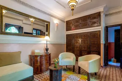 a bedroom with a bed and a table and chairs at Riad Itrane in Marrakech