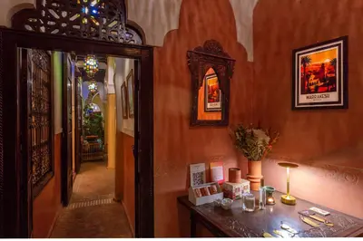 a hallway of a home with a table and a mirror at Riad Itrane in Marrakech