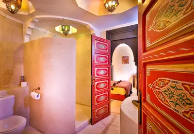 a bathroom with a toilet and a bed in a room at Riad Spa Sindibad in Marrakech