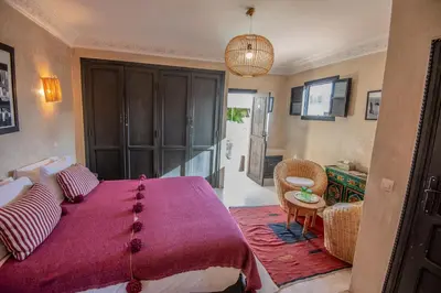 a bedroom with a large bed with a purple blanket at Riad Spa Sindibad in Marrakech
