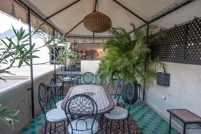 a patio with a table and chairs and plants at Riad Spa Sindibad in Marrakech