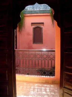 an entrance to a red building with a fence at Riad Aderbaz in Marrakech