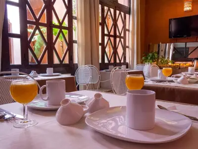 a table with white plates and glasses on it at Riad Aderbaz in Marrakech