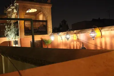 a building with lights on the side of it at night at Riad Louaya in Marrakech