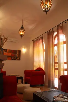 a living room with a red couch and windows at Riad Mariana in Marrakech