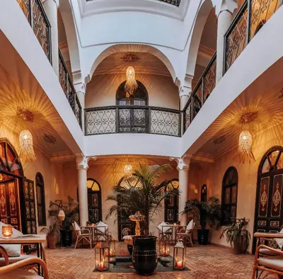 a lobby of a hotel with tables and chairs at Riad Bamaga in Marrakech