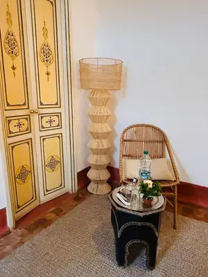 a room with a table and a lamp and a chair at Riad Bamaga in Marrakech