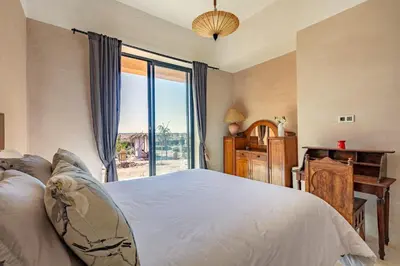 a bedroom with a bed and a large window at La villa Kela Serene 4 suites in Marrakech