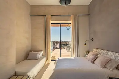 a bedroom with two beds and a large window at La villa Kela Serene 4 suites in Marrakech