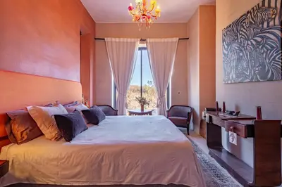a bedroom with a large bed and a chandelier at La villa Kela Serene 4 suites in Marrakech