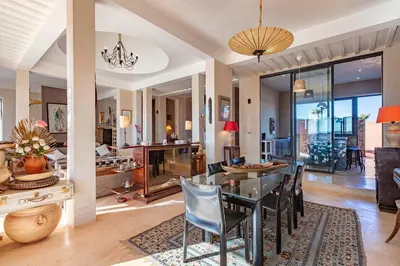 a dining room and living room with a table and chairs at La villa Kela Serene 4 suites in Marrakech
