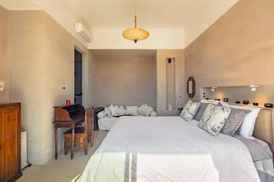 a bedroom with a large bed and a piano at La villa Kela Serene 4 suites in Marrakech