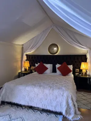 a bedroom with a large bed with red pillows at Riad Des Arts in Marrakech