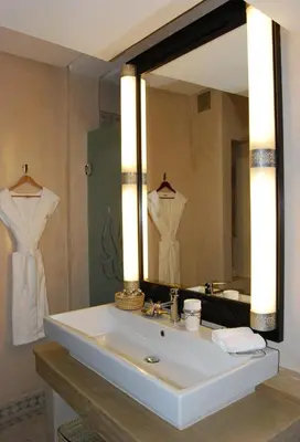 a bathroom with a sink with a large mirror at Riad Flam & Spa in Marrakech