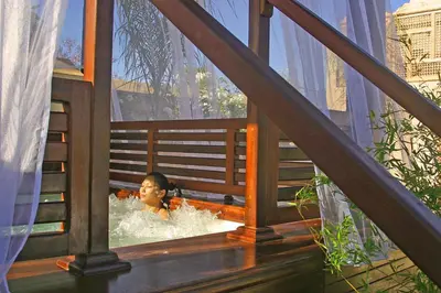 a woman is in a bath tub in a balcony at Riad Flam & Spa in Marrakech