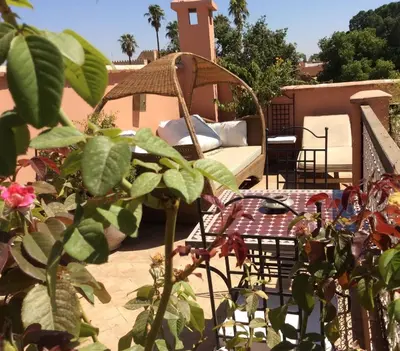 a patio with a couch and a table at Riad Chalymar in Marrakech