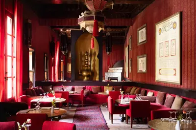 a restaurant with red chairs and tables in a room at Les Jardins De La Koutoubia in Marrakech