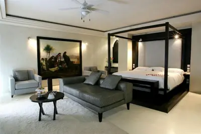 a bedroom with a bed and a couch and a chair at Les Jardins De La Koutoubia in Marrakech