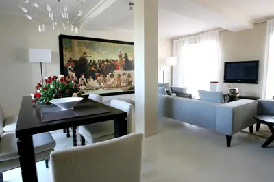 a living room with a dining table and a painting at Les Jardins De La Koutoubia in Marrakech