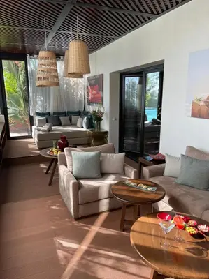 a living room with couches and tables and windows at Les Jardins De La Koutoubia in Marrakech