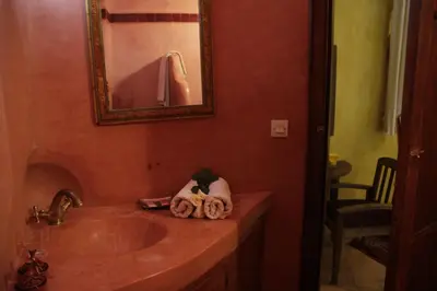 a bathroom with a sink and a mirror at Riad Azenzer in Marrakech