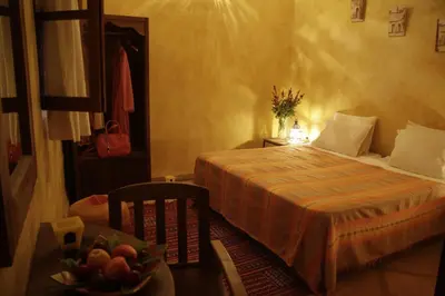 a bedroom with a bed and a bowl of fruit on a table at Riad Azenzer in Marrakech