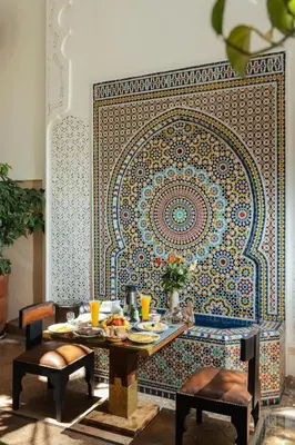 a dining room with a table and a mosaic wall at Riad Anya & SPA in Marrakech