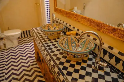 a bathroom with two sinks on a checkered counter at Riad Anya & SPA in Marrakech