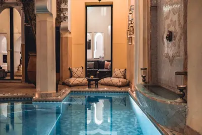 a swimming pool in a building with a house at Ambre Epices Medina Riad in Marrakech