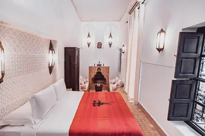 a bedroom with a large white bed with a red blanket at Ambre Epices Medina Riad in Marrakech