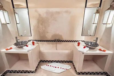 a bathroom with two sinks and two mirrors at Ambre Epices Medina Riad in Marrakech
