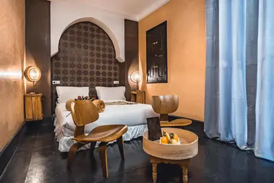 a hotel room with a bed and two chairs at Ambre Epices Medina Riad in Marrakech