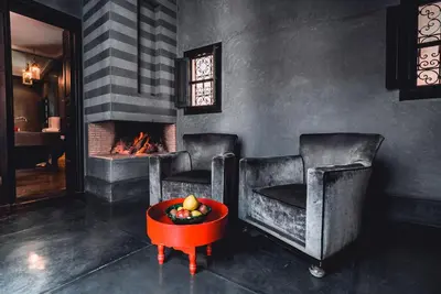 a living room with two chairs and a fireplace at Ambre Epices Medina Riad in Marrakech