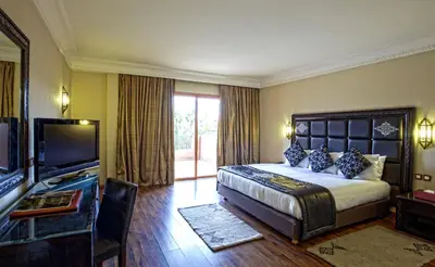 a hotel room with a bed and a television at Palm Plaza Marrakech in Marrakech