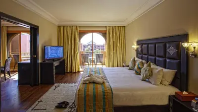 a bedroom with a large bed and a television at Palm Plaza Marrakech in Marrakech
