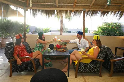 a group of people in party hats sitting around a table at Riad Anyssates in Marrakech