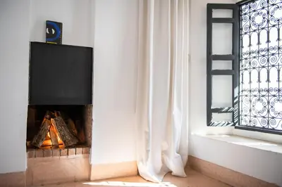a living room with a fireplace and a window at Riyad El Cadi in Marrakech