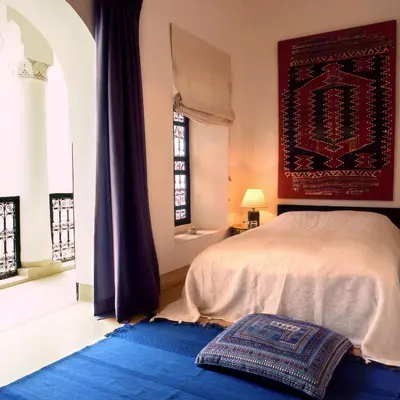 a bedroom with a bed and a blue rug at Riyad El Cadi in Marrakech