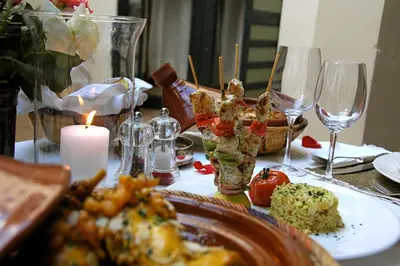 a table topped with plates of food and wine glasses at Riyad El Cadi in Marrakech