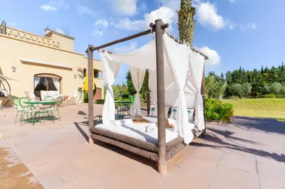 a bed on a patio in front of a house at Palais les sources de l'atlas, Padel & spa in Marrakech