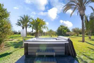 a hot tub in a field with palm trees at Palais les sources de l'atlas, Padel & spa in Marrakech