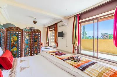 a bedroom with a large bed and a window at Palais les sources de l'atlas, Padel & spa in Marrakech