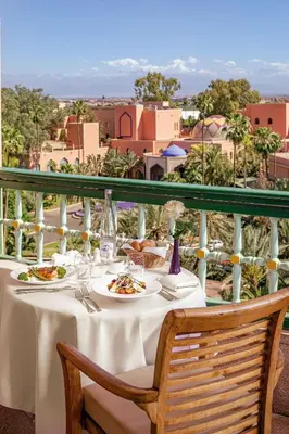 a table with plates of food on a balcony at Es Saadi Marrakech Resort - Hotel in Marrakech