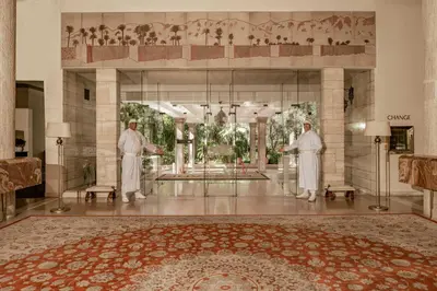 two men standing in a lobby with a large rug at Es Saadi Marrakech Resort - Hotel in Marrakech