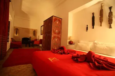 a bedroom with a bed with a red blanket on it at Riad De Vinci & SPA in Marrakech