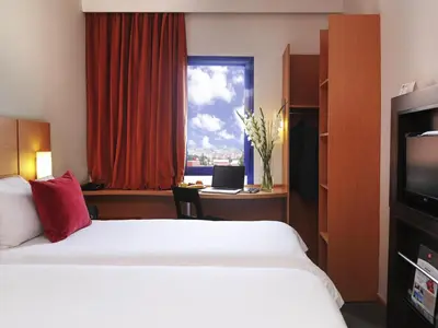 a hotel room with a bed and a window at Ibis Marrakech Centre Gare in Marrakech