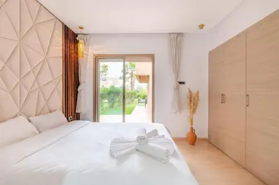 a bedroom with a white bed with a bow on it at Résidence Golfique PJ, jardin, piscine in Marrakech