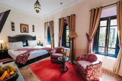 a bedroom with a bed and two chairs at Les Borjs De La Kasbah in Marrakech